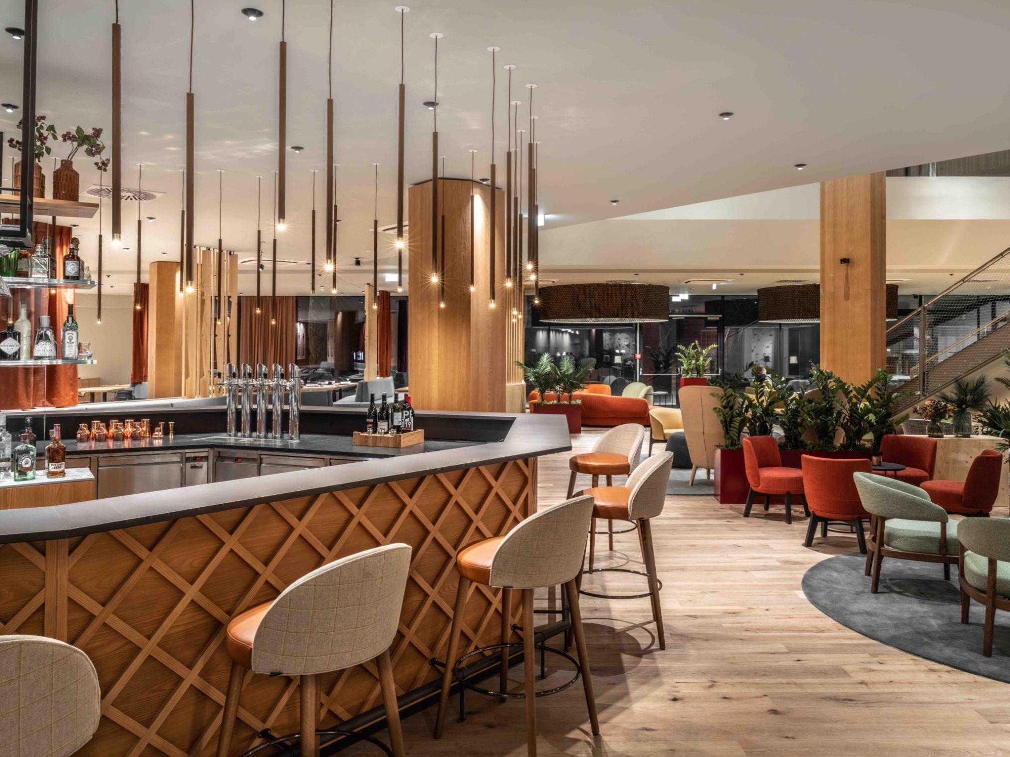 Hotelový bar zve k posezení v útulném prostředí, kde si rodiče mohou vychutnat drink a přitom pozorovat své ratolesti na lezecké stěně v hale