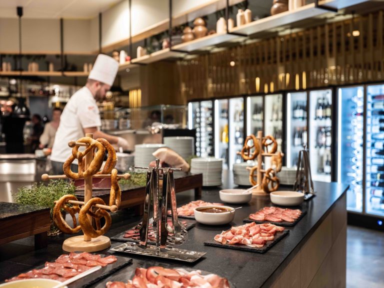 Restaurace láká na bohatý bufet s regionálními specialitami, čerstvými surovinami a atmosférou otevřené kuchyně