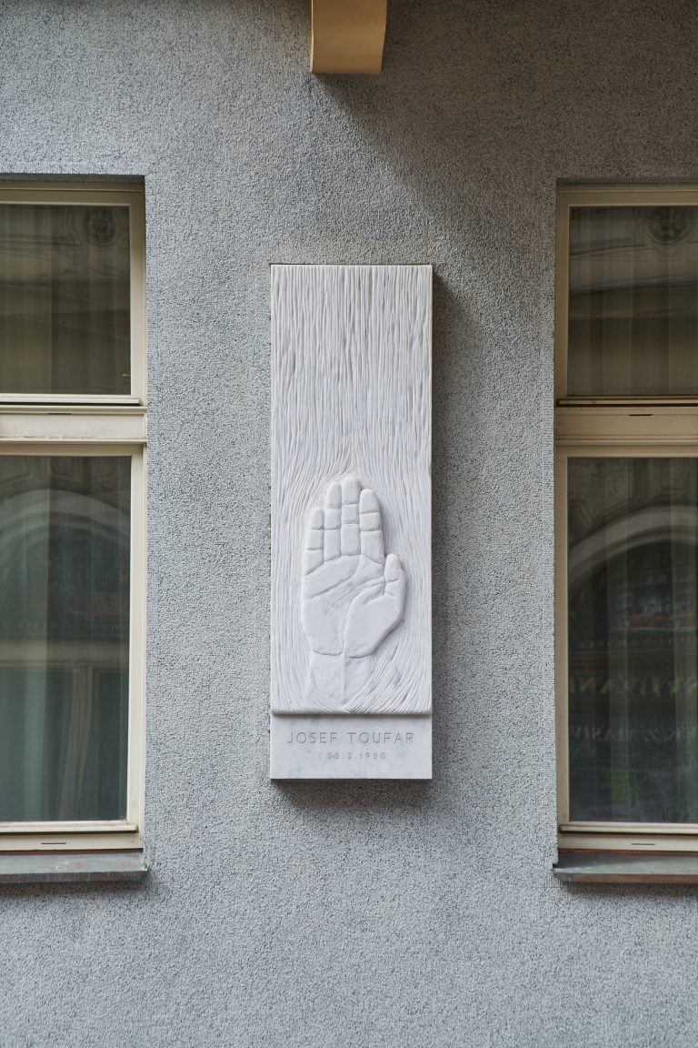 Ruka dlaní k divákovi v pramenu svěcené vody symbolizuje odpuštění a očistu skrze utrpení